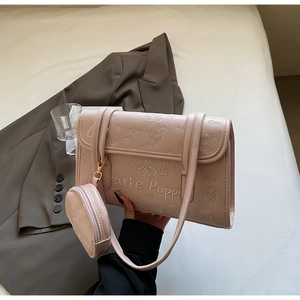 Detalle del bolso de hombro rosa con bordado de cachorros y monedero redondo a juego