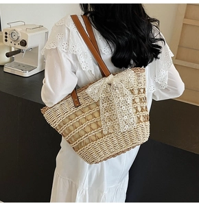 Sac cabas en paille avec nœud en dentelle blanche et anses en cuir marron en situation