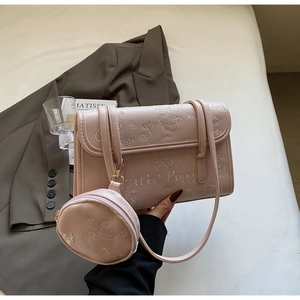 Detalle del bolso de hombro rosa con bordado de perrito y mini monedero redondo