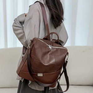 Dettaglio dello zaino vintage in pelle marrone con cuciture patchwork e zip metalliche