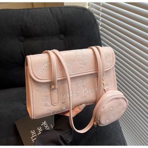 Detalle de bolso de hombro rosa claro con bordado de cachorro y monedero redondo a juego