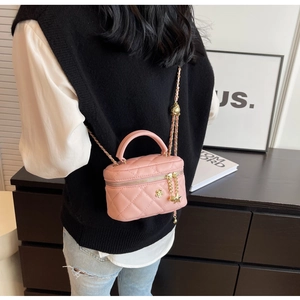 Detail of pink quilted chain bag with adjustable gold ball strap and star pendant
