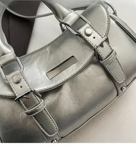 Detailed view of silver Boston bag with wrinkled oil-wax texture and metal rivets