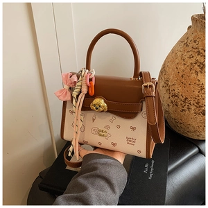 Dettaglio borsa vintage in pelle marrone con chiusura cane dorata e stampe carine