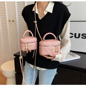 Detail of pink quilted mini crossbody bag with gold hardware and chain strap