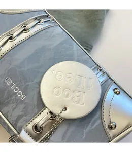 Detail of silver detachable round charm with embossed logo on blue marble bowling bag