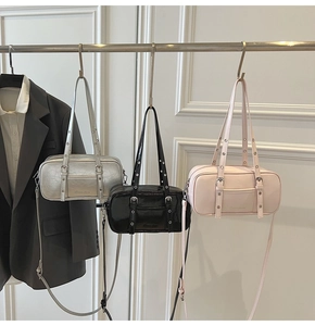 Detailed close-up of retro Boston bags in black, silver and pink with metallic buckles