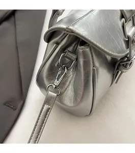 Detail of silver metallic Boston bag featuring pearlescent texture and polished hardware