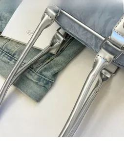 Detail of silver metallic handle and reinforced stitching on blue textured bowling bag