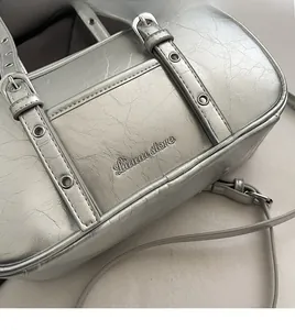 Macro detail of silver Boston bag with wrinkled texture and metal eyelet decorations