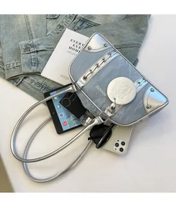 Flat lay of metallic silver shoulder bag showing storage capacity with tech gadgets