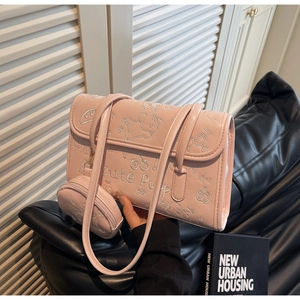 Detalle del bolso rosa de cuero sintético con relieve de cachorro y pequeño monedero redondo