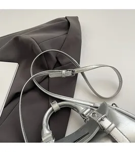 Detail view of adjustable silver shoulder strap with metallic crackle texture and buckle