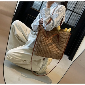 Détail du sac cabas en paille tressée avec lanières en cuir marron et doublure interne