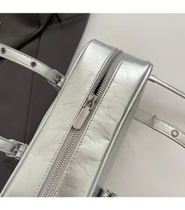 Close-up of smooth silver metal zipper and wrinkled metallic texture on the handbag
