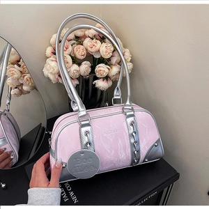 Detailed shot of pink patent leather shoulder bag with silver chain and mirror accents