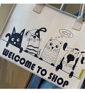 Detailaufnahme des Cartoon-Tierdrucks auf einer cremefarbenen Canvas-Tragetasche aus Stoff