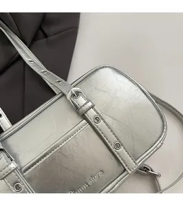 Detail of silver boston bag featuring crinkled metallic texture and adjustable strap