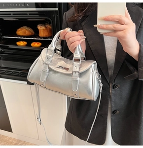 Detail view of silver dumpling bag with metallic pleated texture and buckle accents