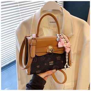Dettaglio borsa retrò marrone con chiusura a cane dorata e fiocco rosa chic