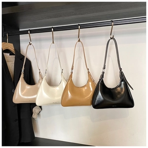 Close-up of minimalist hobo bags in four colors hanging on a metal rod with NO FILTER detail