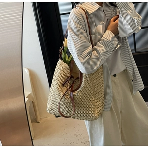 Détail du sac cabas en paille tressée avec lanières en cuir et texture ajourée