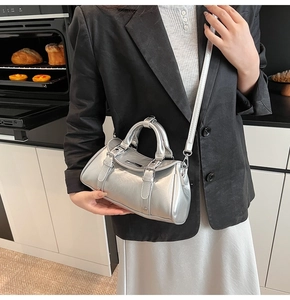 Silver metallic Boston bag with double handles and shoulder strap in lifestyle setting