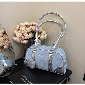Detail of light blue wrinkled handbag with silver metal handles and BOCILEE logo charm