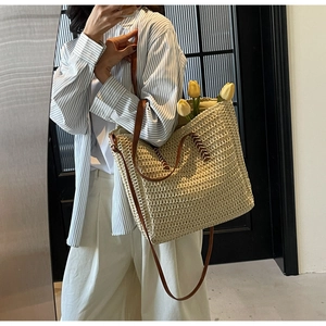 Détail du sac cabas beige tressé avec poignées en cuir marron et décor de tulipes