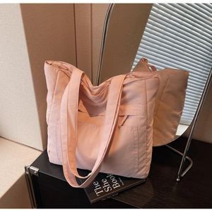 Detail of pink padded tote bag showing soft quilted texture and large front pocket