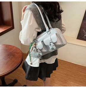Dettaglio della borsa Boston azzurra in ecopelle con tasche e ciondolo a forma di orso