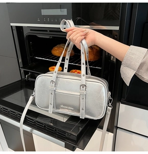 Detail showing the silver glossy texture and metal rivet accents of this Boston handbag