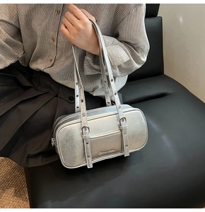 Close-up of silver Boston bag with metallic cracked texture and metal eyelet straps