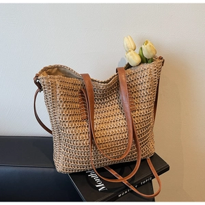 Gros plan sur la texture du sac cabas en paille tressée avec poignée en cuir