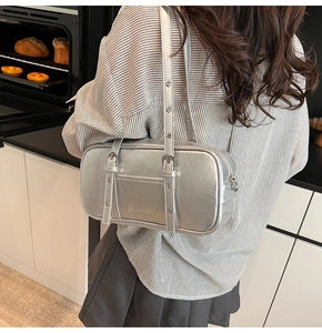 Silver rectangle shoulder bag with metallic texture shown in a lifestyle kitchen setting