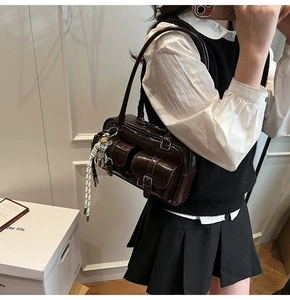 Dettaglio della borsa a spalla marrone scuro in vernice con doppie tasche frontali