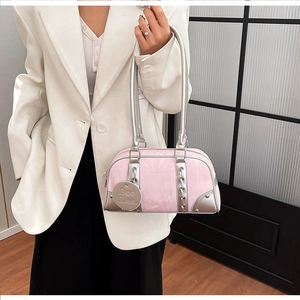 Pink patent leather shoulder bag with silver trim and logo detail on white blazer