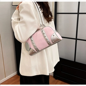 Detailed view of pink and silver shoulder bag with metallic studs and logo tag