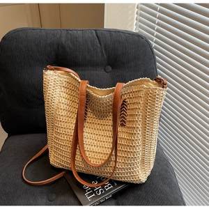 Vue détaillée du sac cabas en paille tissée avec anses et bandoulière en cuir brun