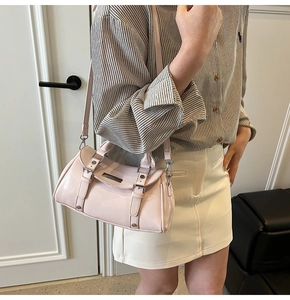 Close-up of pink glossy patent leather texture and silver buckle details on the bag