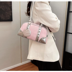 Detail of pink patent leather boston bag with silver metal corners and brand logo