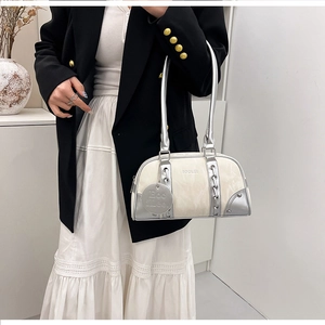 Detail of white textured leather shoulder bag with silver trim and metallic chain