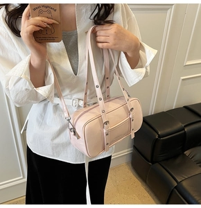 Detailed view of pink barrel bag showing adjustable metal eyelet straps and smooth texture