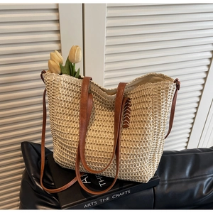 Détail du sac cabas en paille beige avec poignées en similicuir marron et tulipes