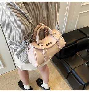 Detail of pink patent leather Boston bag with silver hardware and adjustable strap