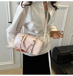 Pink glossy leather Boston bag shown with crossbody strap on a model for daily style