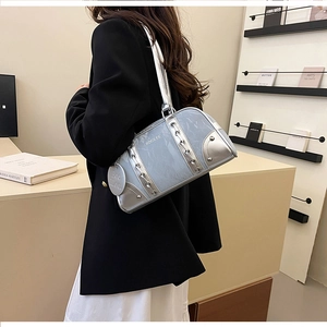 Detailed view of light blue and silver cylinder bag with metal studs on a shoulder strap