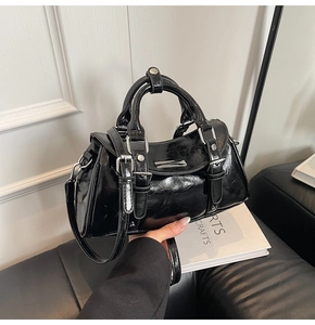 Detail of Boston handbag with glossy black oil-wax texture and silver metal hardware studs