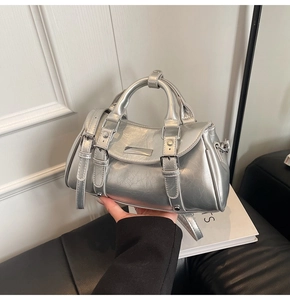 Detail of silver dumpling bag with metallic texture, buckles and adjustable strap