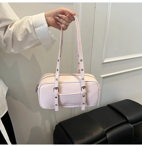 Detail of light pink rectangular bowling bag with adjustable eyelet shoulder strap